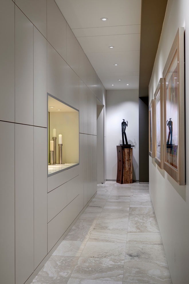 This is an example of a mid-sized contemporary hallway in Indianapolis with white walls, travertine floors and grey floor.