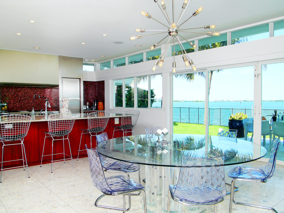 Photo of a contemporary galley eat-in kitchen in Miami with flat-panel cabinets, stainless steel cabinets, red splashback, mosaic tile splashback and stainless steel appliances.