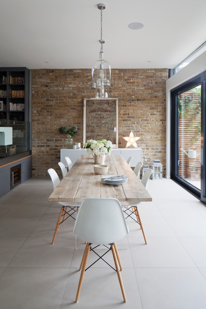 Large country open plan dining in London with porcelain floors, no fireplace, white walls and grey floor.
