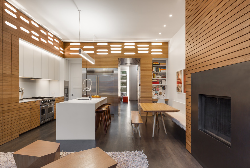 Design ideas for a mid-sized contemporary l-shaped open plan kitchen in Omaha with an undermount sink, louvered cabinets, medium wood cabinets, white splashback, stainless steel appliances, dark hardwood floors, with island, brown floor, white benchtop and quartz benchtops.