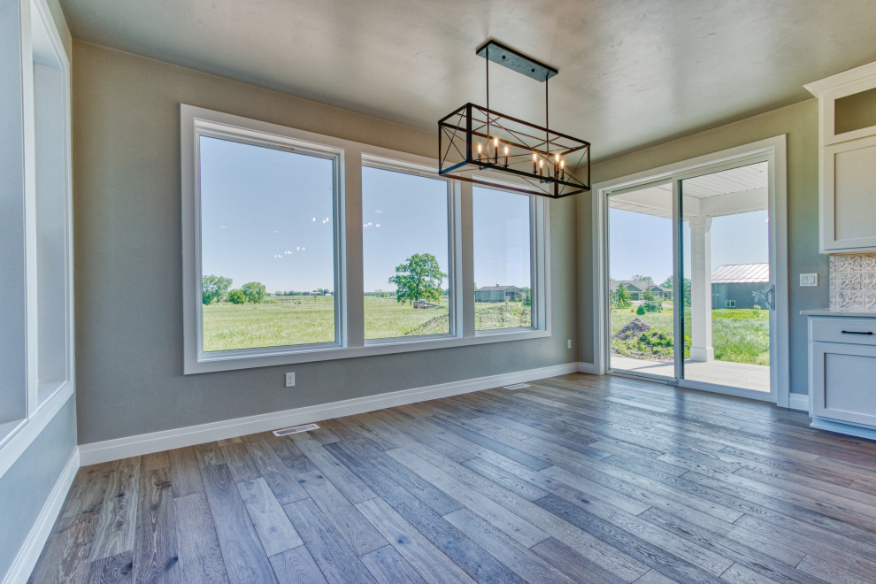 Mid-sized transitional light wood floor and brown floor kitchen/dining room combo photo with gray walls and no fireplace