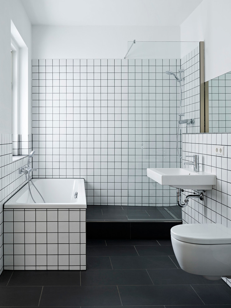 Badezimmer With Wandwaschbecken, Einbaubadewanne, offener Dusche, Wandtoilette, weißen Fliesen and weißer Wandfarbe in Leipzig