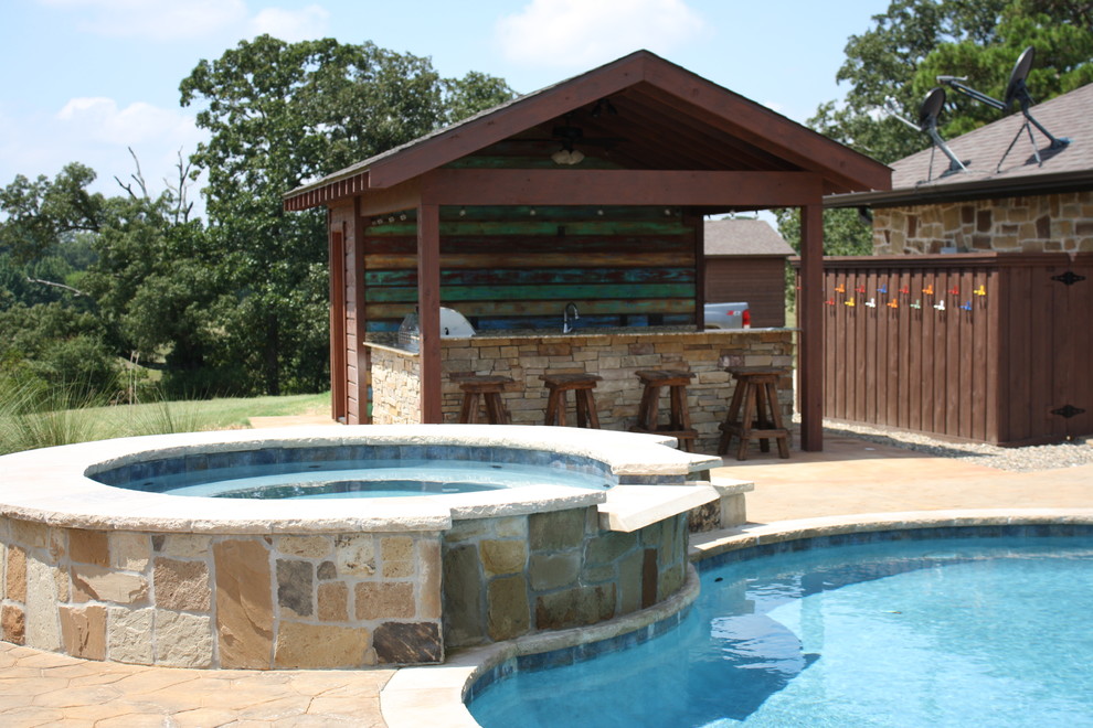 Large country backyard custom-shaped pool in New Orleans with a pool house and natural stone pavers.