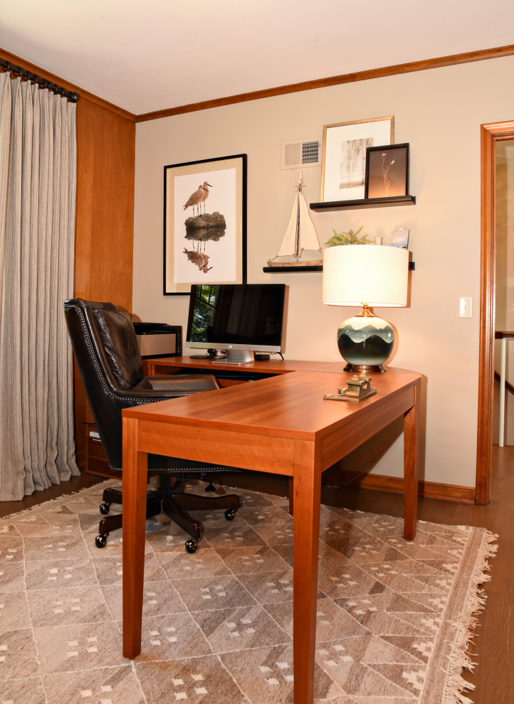 Elegant freestanding desk medium tone wood floor, brown floor and wall paneling study room photo in Minneapolis with beige walls