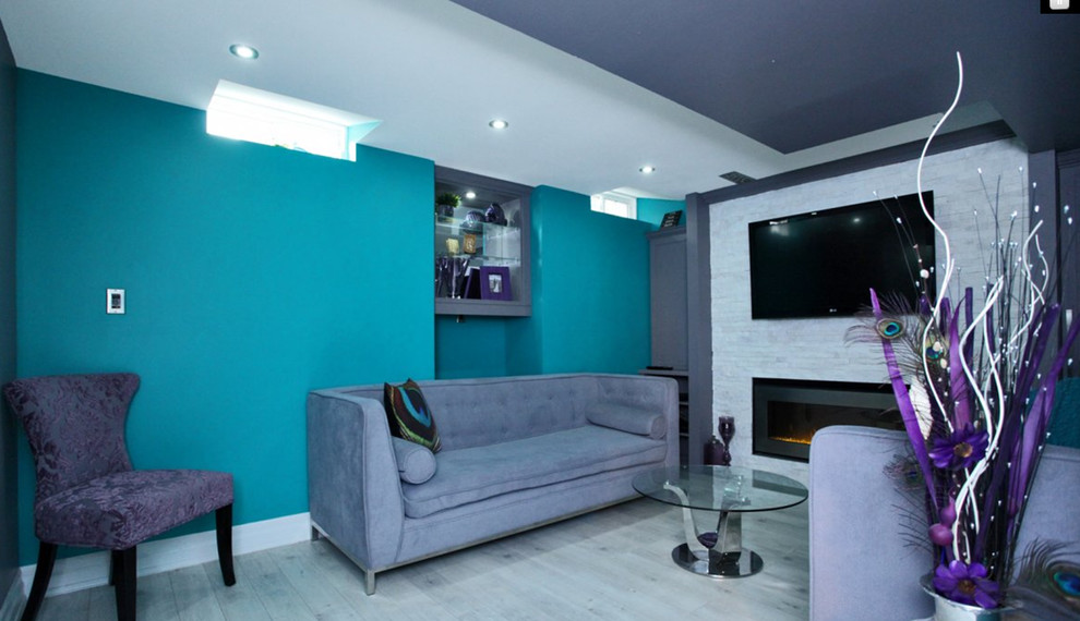 Basement - transitional look-out laminate floor and gray floor basement idea in Toronto with multicolored walls, a standard fireplace and a stone fireplace