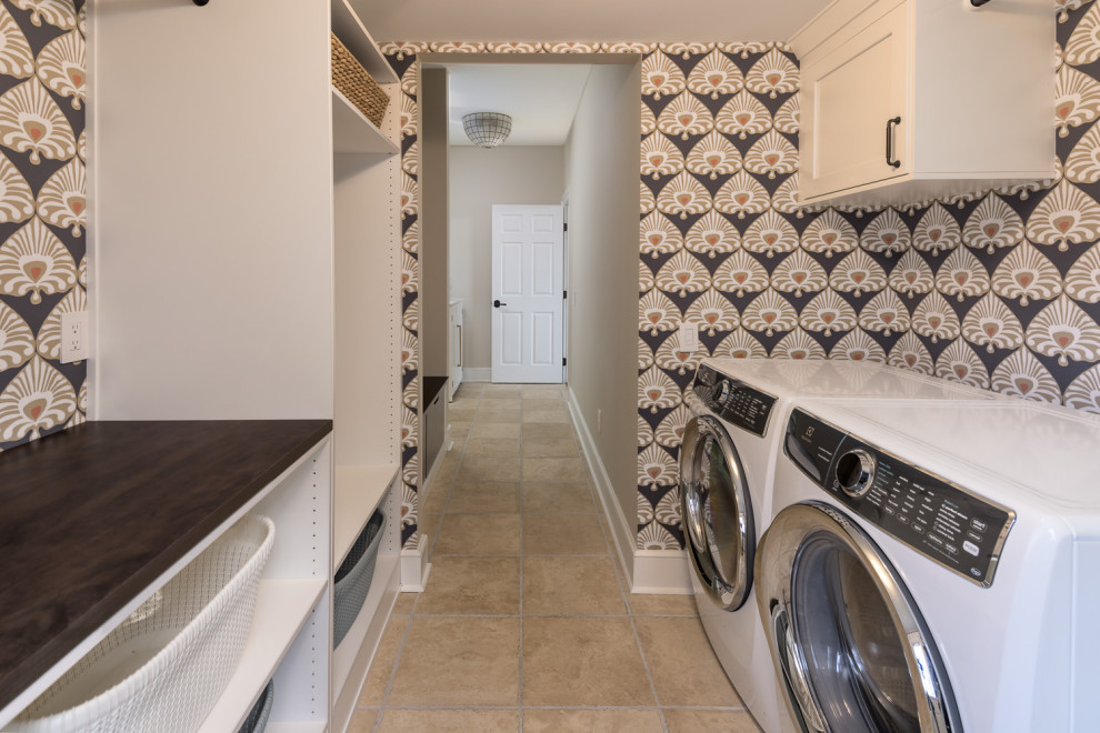 Foto på en mellanstor parallell tvättstuga enbart för tvätt, med en undermonterad diskho, skåp i shakerstil, vita skåp, träbänkskiva, blå väggar, travertin golv, en tvättmaskin och torktumlare bredvid varandra och beiget golv
