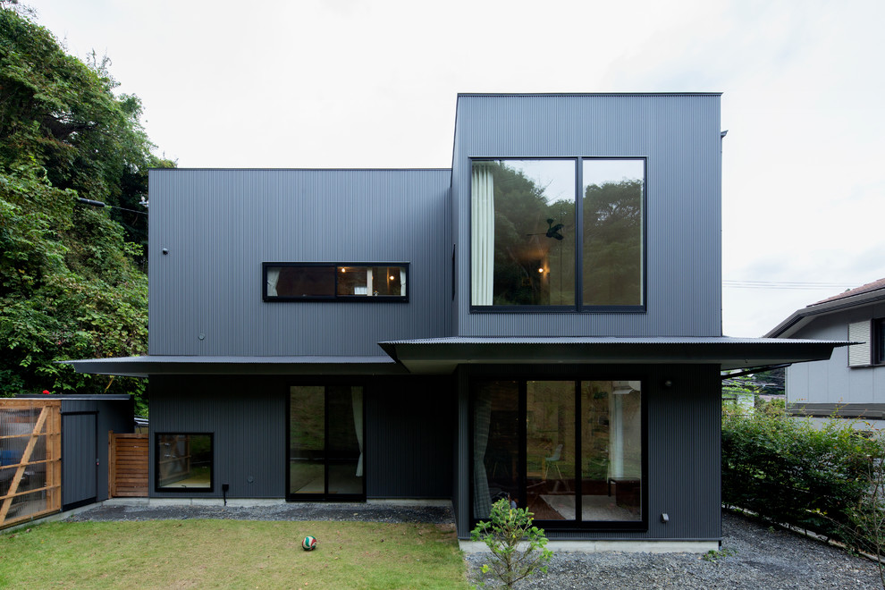 Inspiration for a contemporary two-storey black exterior in Other with a flat roof.
