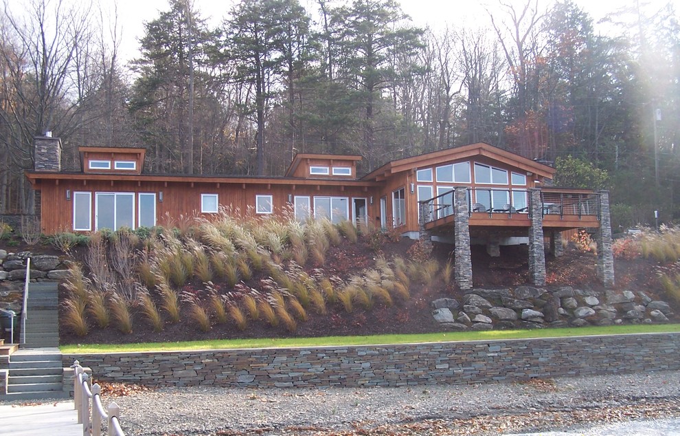 Diseño de fachada de casa marrón, contemporánea, de tamaño medio, de una planta, con revestimiento de madera, tejado a dos aguas y tejado de teja de madera