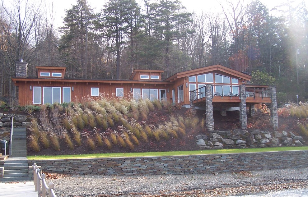 Diseño de fachada de casa marrón contemporánea de tamaño medio de una planta con revestimiento de madera, tejado a dos aguas y tejado de teja de madera