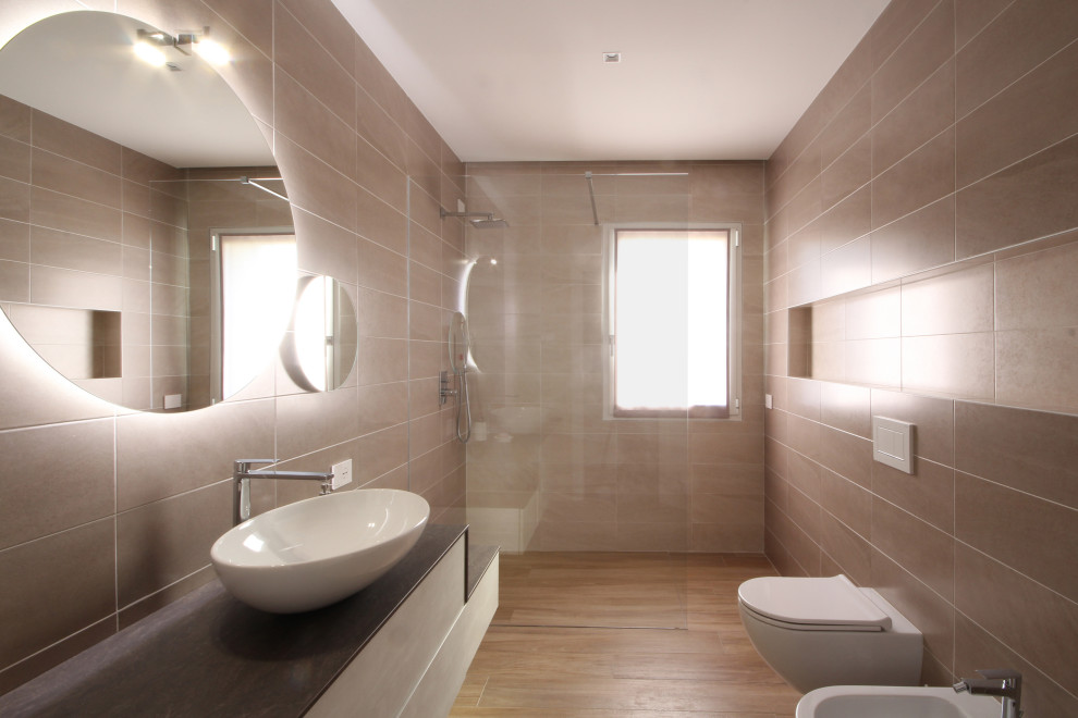 Idéer för ett stort modernt brun en-suite badrum, med släta luckor, en kantlös dusch, en toalettstol med separat cisternkåpa, brun kakel, keramikplattor, bruna väggar, målat trägolv, ett konsol handfat, marmorbänkskiva, gult golv och med dusch som är öppen