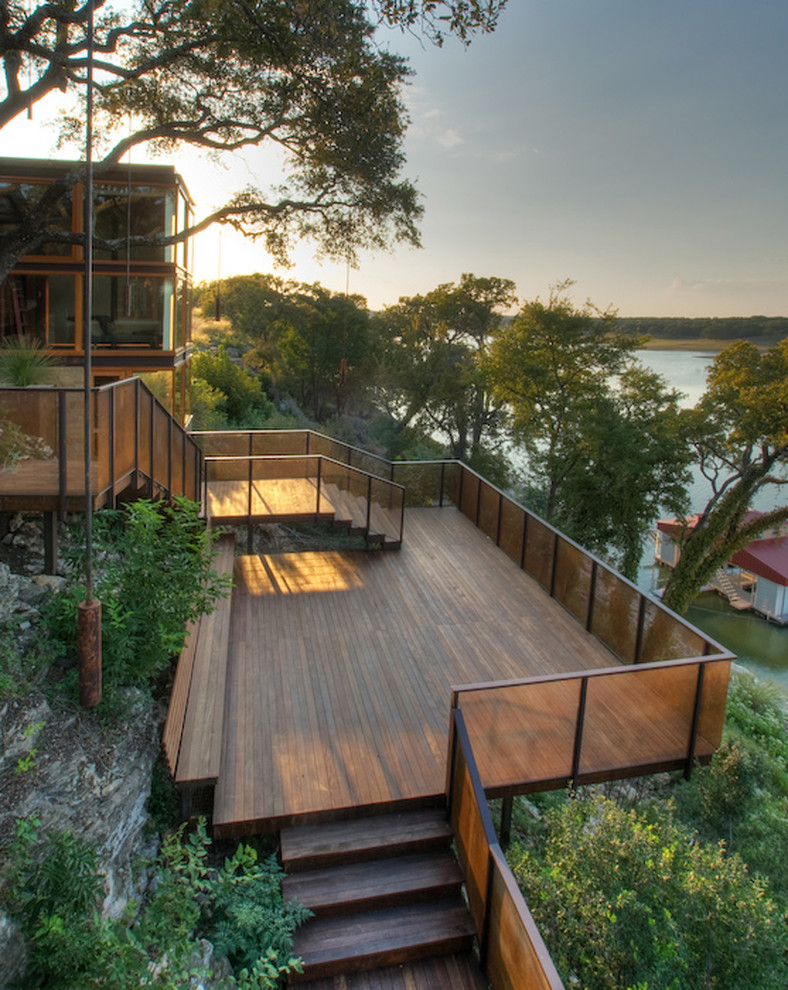 This is an example of a large modern backyard deck in Austin with no cover.