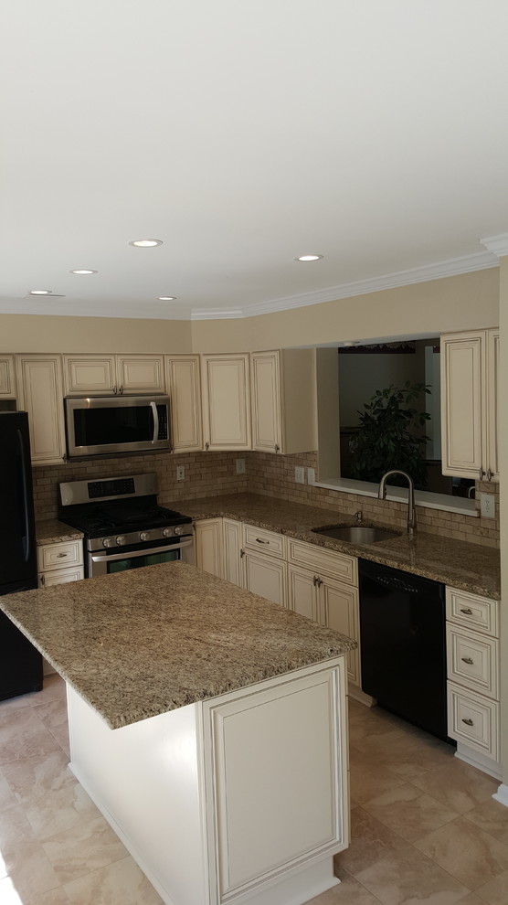 This is an example of a mid-sized traditional l-shaped kitchen in DC Metro with beige cabinets, granite benchtops, beige splashback, stone tile splashback, black appliances, porcelain floors and with island.