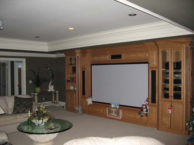 Design ideas for a mid-sized traditional enclosed home theatre in Other with grey walls, carpet and a built-in media wall.