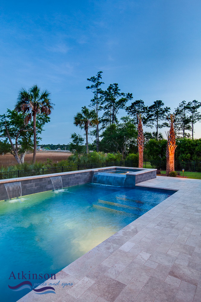 Mid-sized contemporary backyard rectangular natural pool in Charleston with natural stone pavers and a hot tub.