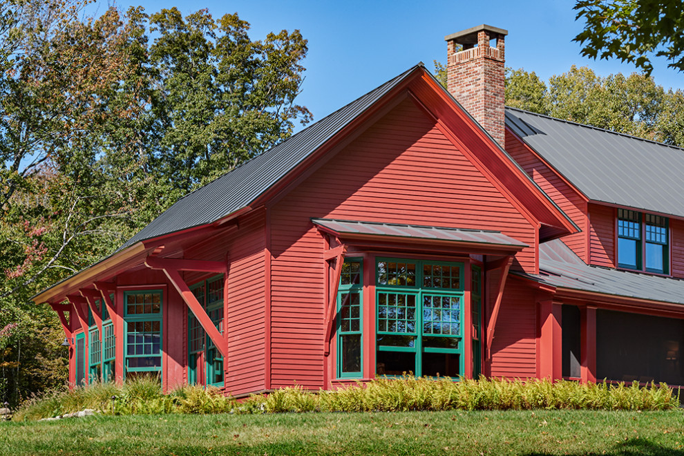 Идея дизайна: деревянный, красный частный загородный дом в стиле кантри с двускатной крышей, металлической крышей, серой крышей и отделкой планкеном