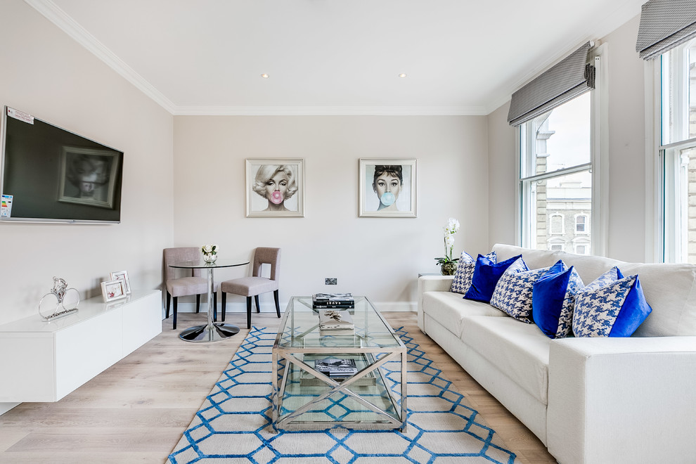 Contemporary enclosed living room in London with beige walls, light hardwood flooring, no fireplace and a wall mounted tv.