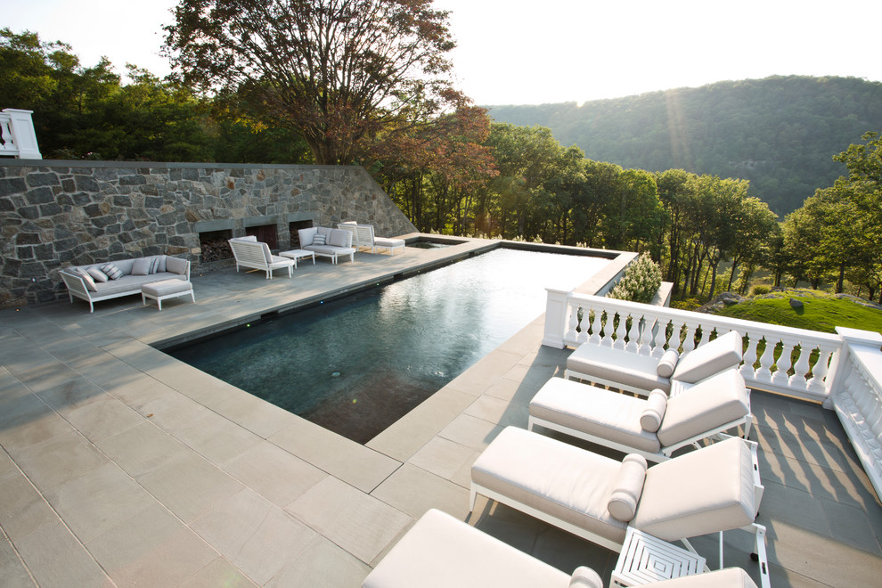Inspiration for a large arts and crafts side yard rectangular lap pool in New York with a hot tub and natural stone pavers.