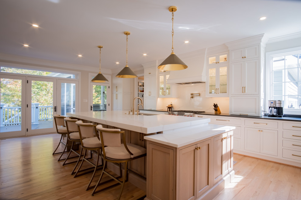 Inspiration for a large traditional l-shaped eat-in kitchen in DC Metro with an undermount sink, beaded inset cabinets, light wood cabinets, soapstone benchtops, white splashback, engineered quartz splashback, stainless steel appliances, light hardwood floors, with island, brown floor, black benchtop and wallpaper.