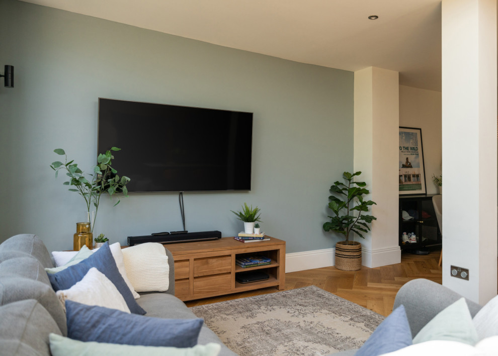 На фото: большая открытая гостиная комната в современном стиле с полом из винила и телевизором на стене с