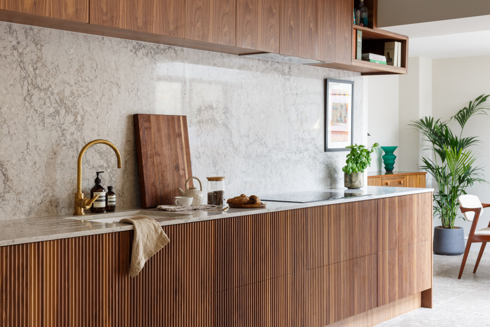 Example of a mid-sized minimalist galley eat-in kitchen design in Other with flat-panel cabinets, dark wood cabinets, quartzite countertops, paneled appliances and no island