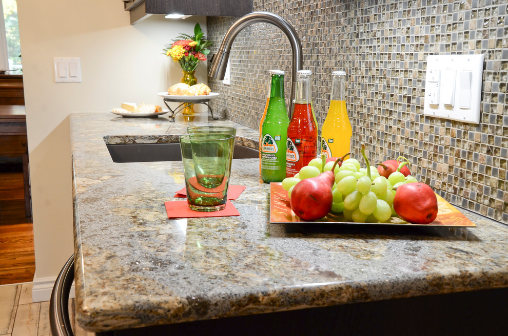 Kitchen - mid-sized transitional galley porcelain tile kitchen idea in Ottawa with an undermount sink, glass-front cabinets, brown cabinets, quartz countertops, brown backsplash, glass sheet backsplash and stainless steel appliances