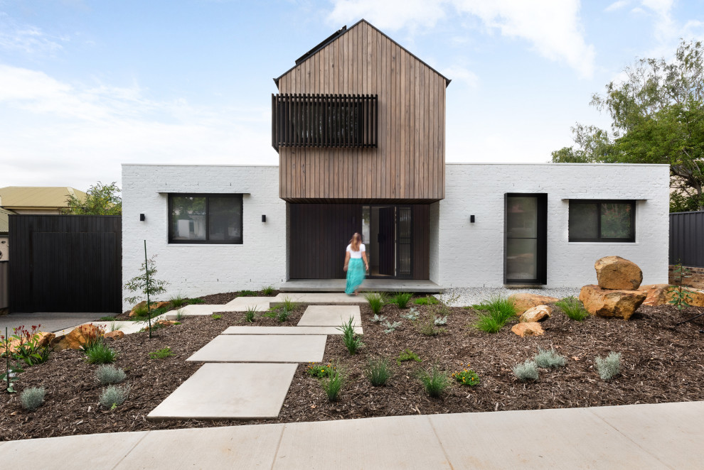 Foto de fachada de casa gris moderna de tamaño medio de dos plantas con revestimiento de ladrillo, tejado a dos aguas y tejado de metal