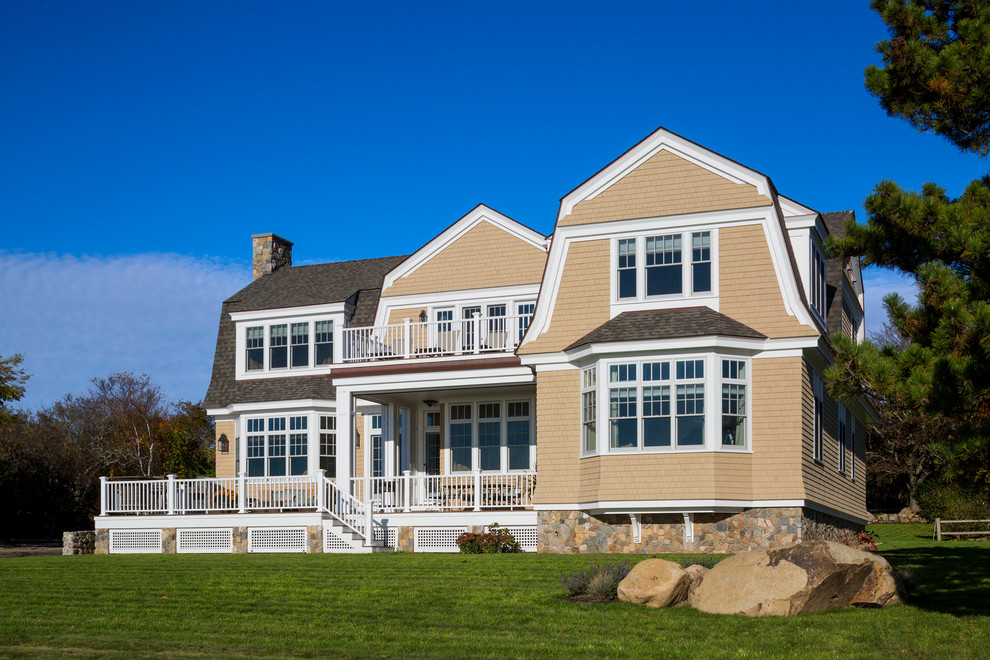 This is an example of a large beach style two-storey yellow exterior in Boston with wood siding.