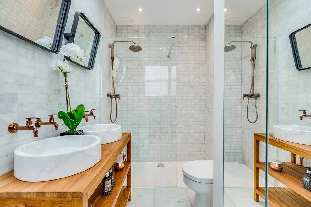 This is an example of a small transitional bathroom in London with open cabinets, a one-piece toilet, marble, white walls, ceramic floors, a vessel sink, white floor, an open shower, medium wood cabinets, an open shower and white tile.