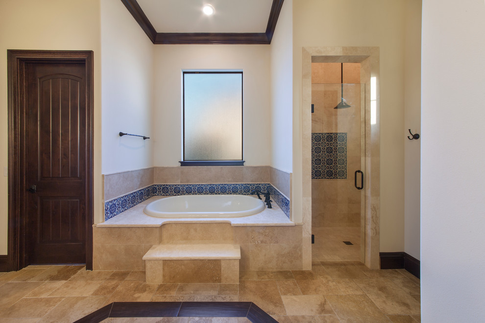 Design ideas for an expansive mediterranean master bathroom in Orlando with raised-panel cabinets, dark wood cabinets, a drop-in tub, a curbless shower, a one-piece toilet, blue tile, ceramic tile, beige walls, travertine floors, a drop-in sink and granite benchtops.
