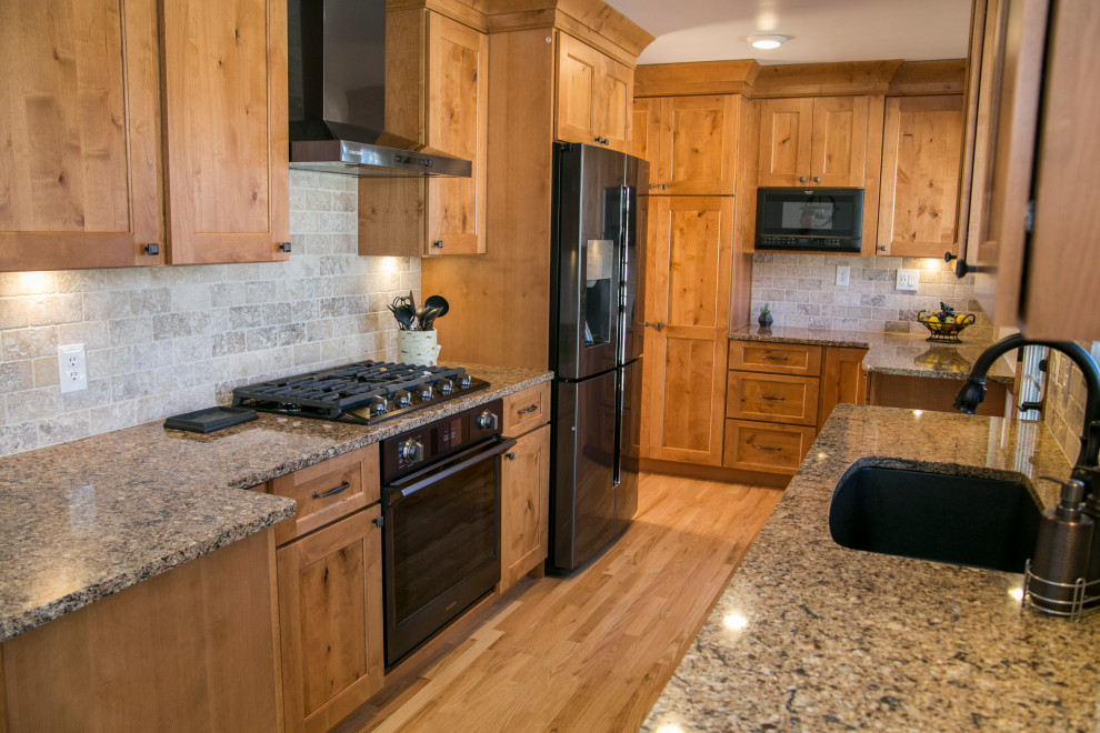 Eat-in kitchen - mid-sized rustic galley medium tone wood floor and brown floor eat-in kitchen idea in Denver with an undermount sink, shaker cabinets, medium tone wood cabinets, quartz countertops, gray backsplash, stone tile backsplash, black appliances, no island and brown countertops