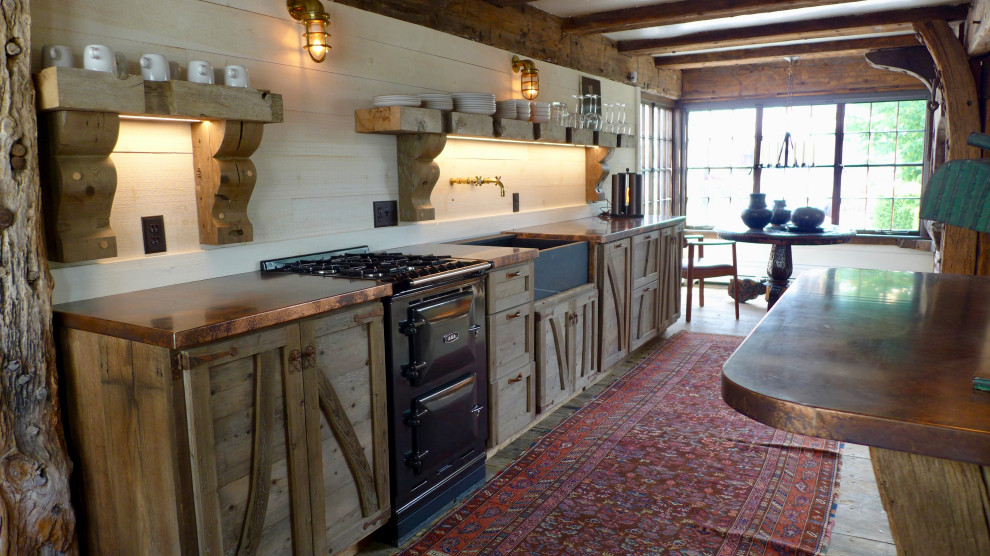 Country kitchen in Boston with a farmhouse sink, copper benchtops and timber splashback.