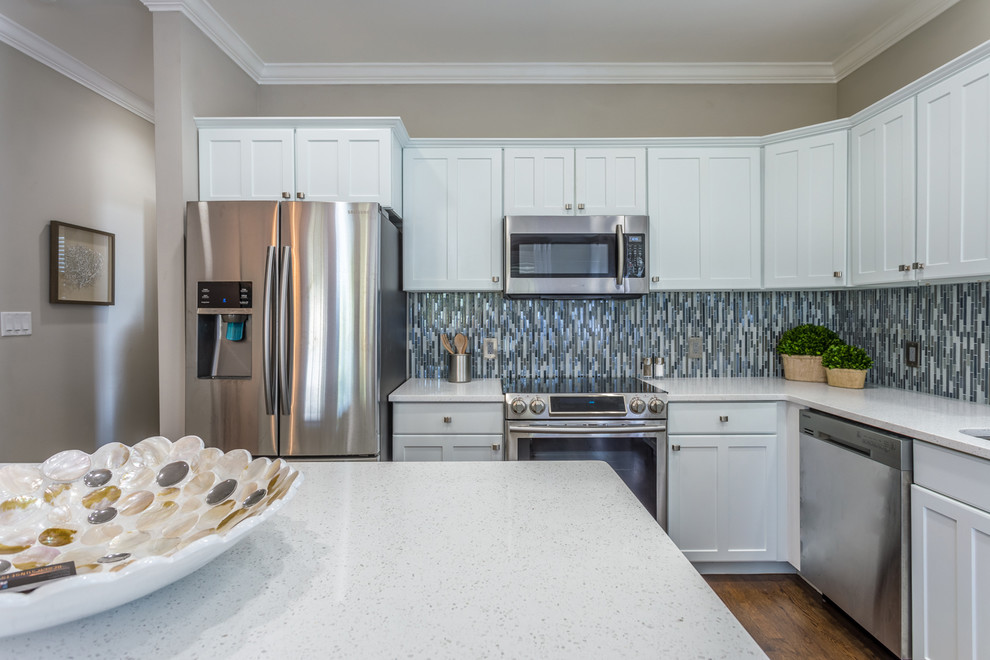 Inspiration for a mid-sized transitional l-shaped dark wood floor and brown floor open concept kitchen remodel in Miami with an undermount sink, shaker cabinets, white cabinets, quartz countertops, multicolored backsplash, mosaic tile backsplash, stainless steel appliances and an island