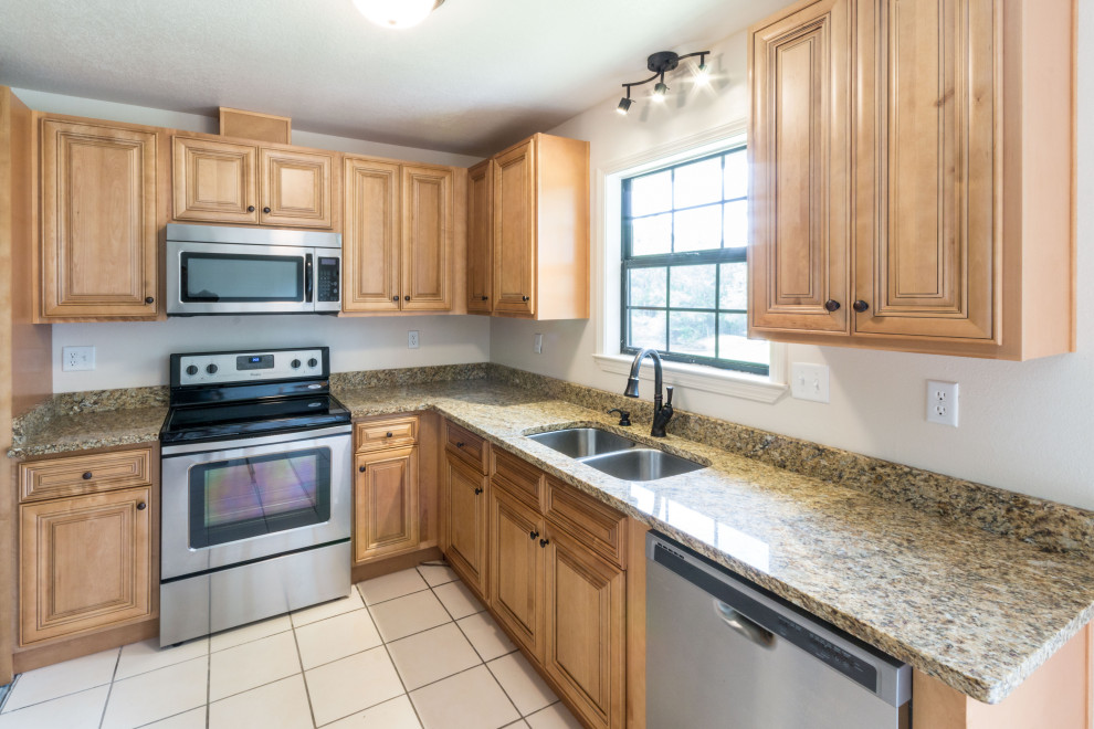 Example of a mid-sized l-shaped eat-in kitchen design with an undermount sink, raised-panel cabinets, medium tone wood cabinets, granite countertops, ceramic backsplash, stainless steel appliances, a peninsula and brown countertops