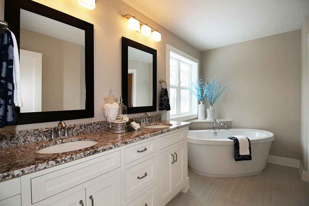Design ideas for a mid-sized transitional master bathroom in Minneapolis with shaker cabinets, white cabinets, a freestanding tub, an open shower, a two-piece toilet, gray tile, ceramic tile, grey walls, porcelain floors, an undermount sink and granite benchtops.