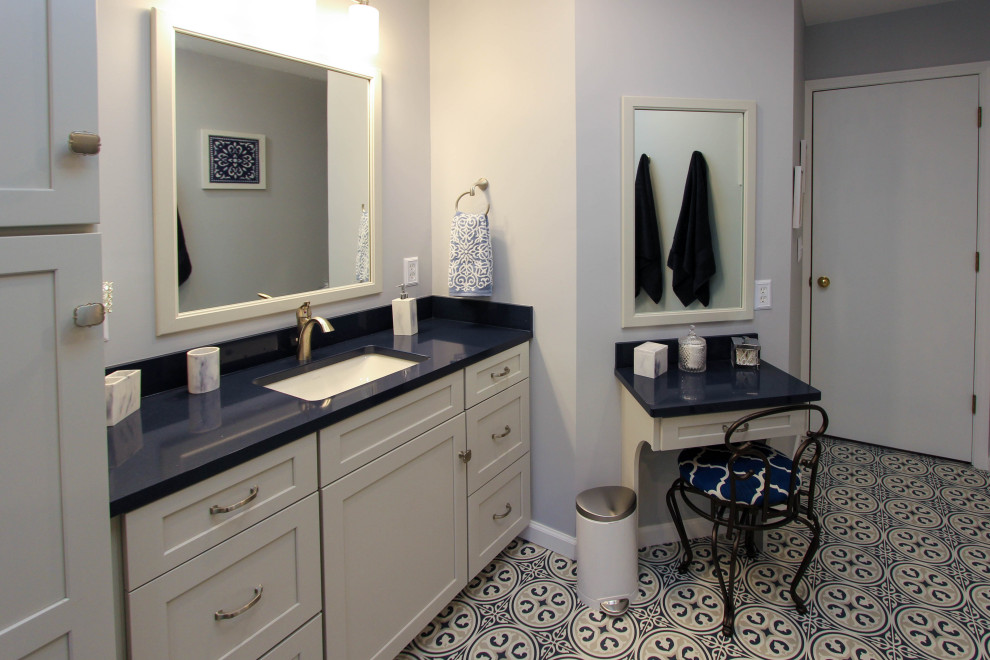 Mid-sized transitional master bathroom in Cleveland with flat-panel cabinets, grey cabinets, a freestanding tub, a corner shower, a two-piece toilet, gray tile, subway tile, grey walls, limestone floors, an undermount sink, engineered quartz benchtops, blue floor, a hinged shower door and blue benchtops.