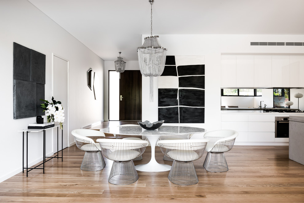 This is an example of a mid-sized contemporary open plan dining in Melbourne with white walls, medium hardwood floors, no fireplace and brown floor.