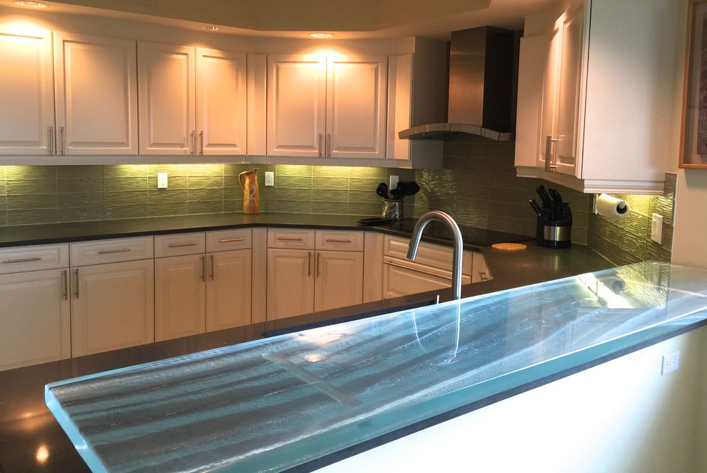 Mid-sized transitional u-shaped eat-in kitchen photo with raised-panel cabinets, white cabinets, solid surface countertops, green backsplash, glass tile backsplash, stainless steel appliances and an island