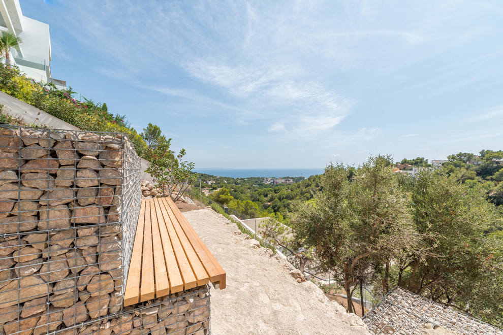 マヨルカ島にある地中海スタイルのおしゃれな一戸建ての家 (石材サイディング、外階段) の写真