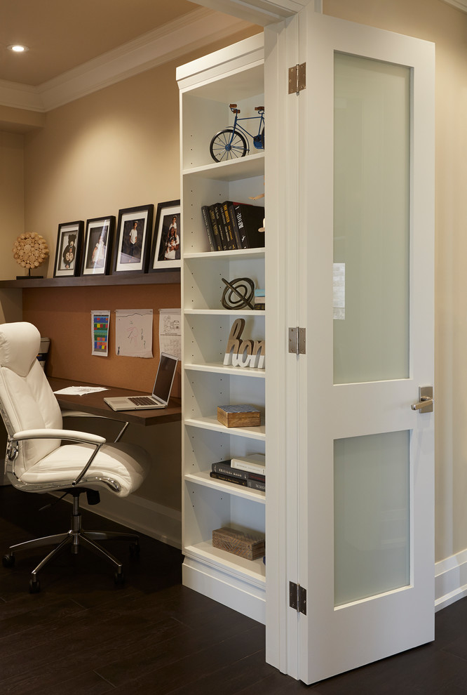 This is an example of a small contemporary home office in Toronto with brown walls, dark hardwood floors, a built-in desk and brown floor.