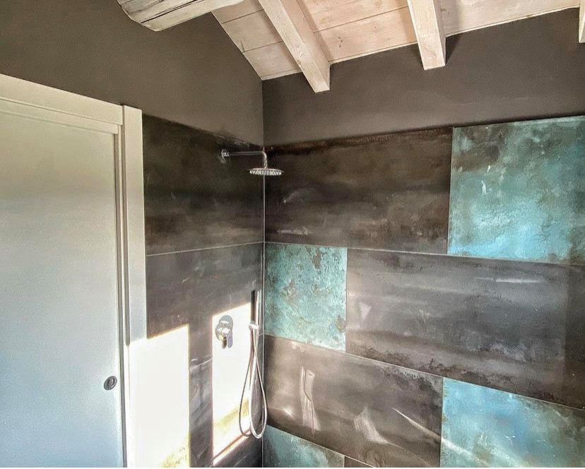 Ispirazione per un bagno di servizio con piastrelle multicolore, pareti marroni e travi a vista