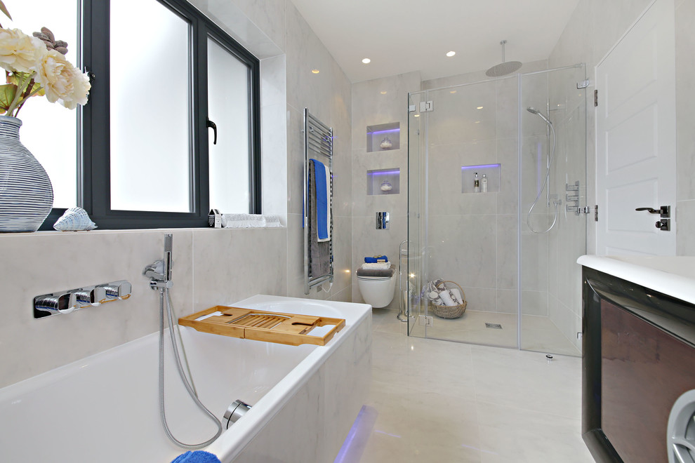 Inspiration for a large modern master bathroom in Hertfordshire with raised-panel cabinets, light wood cabinets, a freestanding tub, an open shower, a wall-mount toilet, white tile, porcelain tile, white walls, porcelain floors, a wall-mount sink, solid surface benchtops, white floor, a hinged shower door and white benchtops.