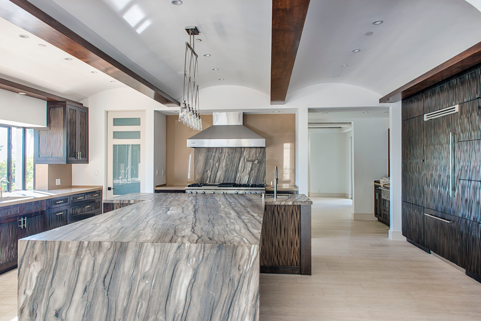 Transitional kitchen in Los Angeles with marble benchtops, stone slab splashback, limestone floors and with island.