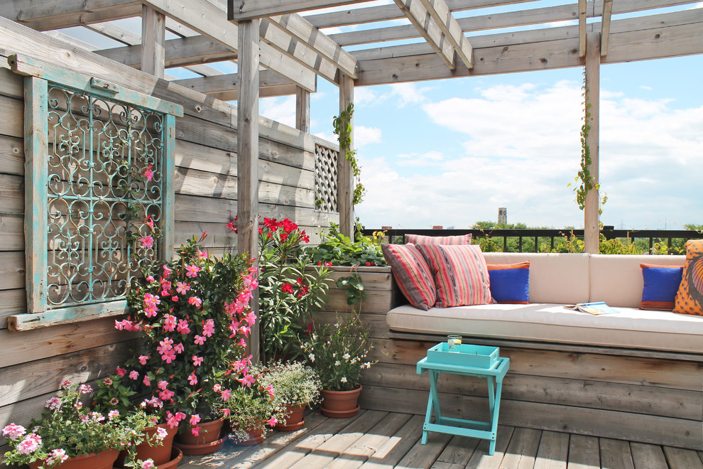 Inspiration for a mid-sized contemporary rooftop deck in Montreal with a pergola.