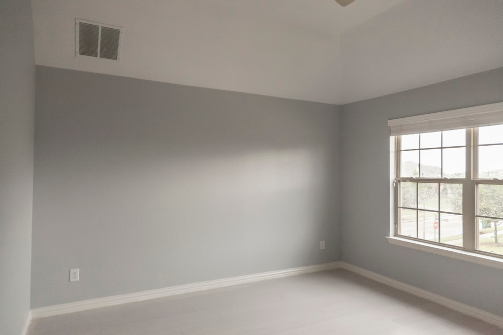 Foto di una camera degli ospiti minimalista di medie dimensioni con pareti grigie, pavimento in bambù e nessun camino