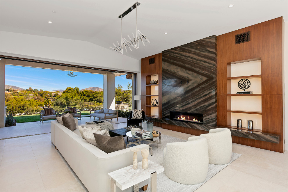 Offenes Modernes Wohnzimmer mit weißer Wandfarbe, Gaskamin, Kaminumrandung aus Stein und beigem Boden in San Diego