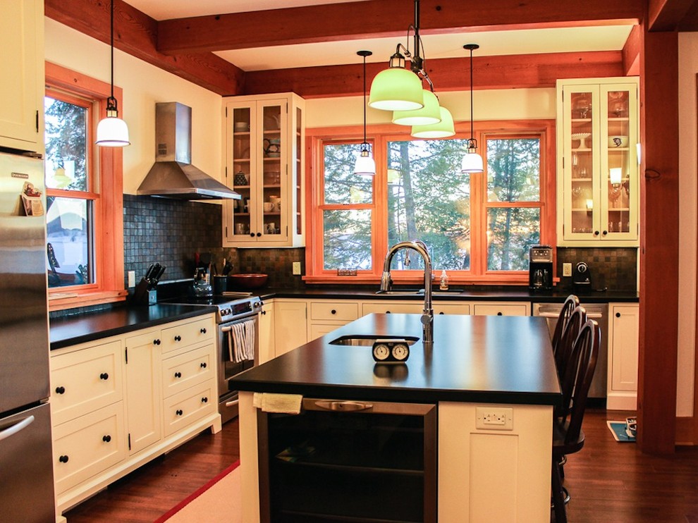 Large mountain style l-shaped medium tone wood floor eat-in kitchen photo in Toronto with a drop-in sink, glass-front cabinets, beige cabinets, marble countertops, metallic backsplash, ceramic backsplash, stainless steel appliances and an island