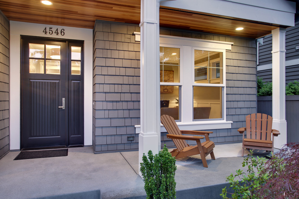 Photo of an arts and crafts front yard verandah in Seattle with a roof extension and concrete slab.