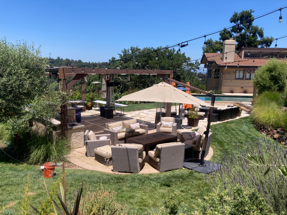 Design ideas for an expansive rustic back patio in San Francisco with a fire feature, natural stone paving and a pergola.