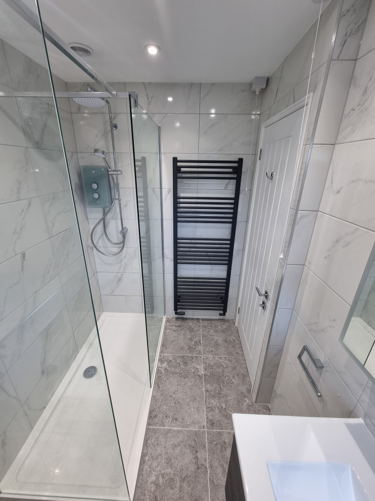 Design ideas for a small contemporary grey and white family bathroom in West Midlands with flat-panel cabinets, dark wood cabinets, a walk-in shower, a wall mounted toilet, white tiles, porcelain tiles, white walls, porcelain flooring, a wall-mounted sink, grey floors, an open shower, a single sink and a floating vanity unit.