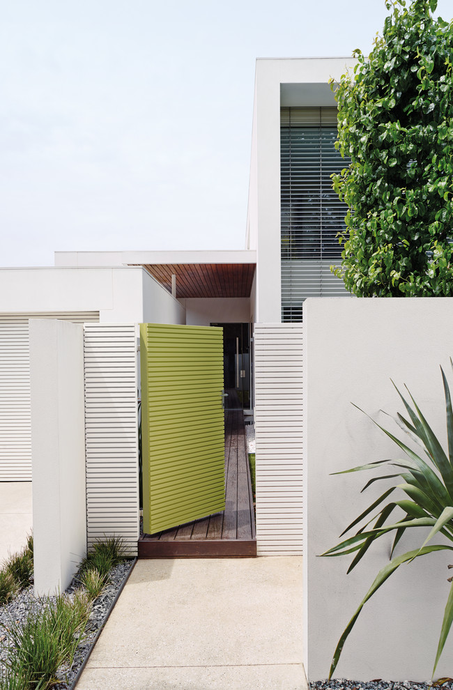 Photo of a mid-sized contemporary two-storey white exterior in Melbourne.